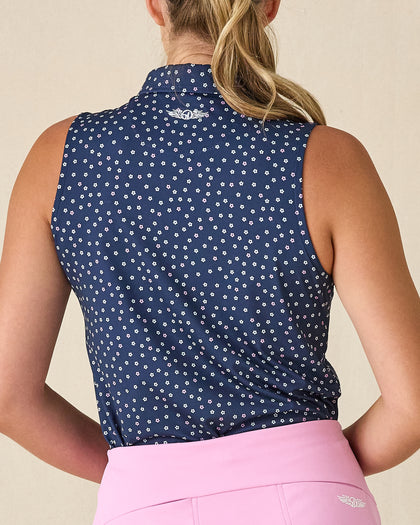 Cherry Bloom Sleeveless Polo in New Indigo, back view on model featuring a navy base with scattered white and pink floral print and Straight Down logo embroidered at center back, paired with a pink skort