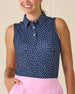 Cherry Bloom Sleeveless Polo in New Indigo, front view on model featuring a navy base with scattered white and pink floral print, paired with a pink skort