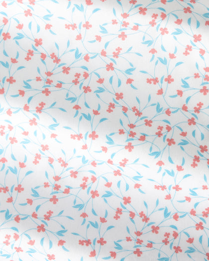White fabric with a delicate repeating floral pattern of small coral-pink blossoms and light blue leaves on thin stems.