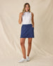 Valerie Sleeveless Polo in Spritz, full length front view featuring a white base with coral floral and light blue vine allover print pattern, paired with a navy skort and white golf shoes