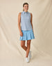Milano Sleeveless Polo in Gemstone, full length front view featuring a white base with navy geometric medallion allover print pattern, paired with a light blue pleated skort and white golf shoes