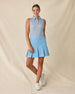 Milano Sleeveless Polo in Gemstone, full length side angle view featuring a white base with navy geometric medallion allover print pattern, paired with a light blue pleated skort and white golf shoes