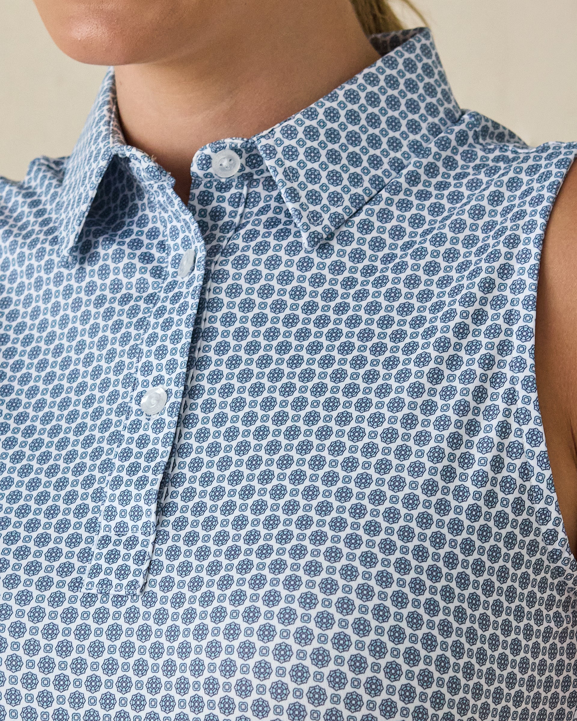 Milano Sleeveless Polo in Gemstone, close-up detail view featuring navy geometric medallion print on a white base with pearl buttons