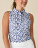 Moloka'i Sleeveless Polo in Moonlight, front view on model featuring a slate blue base with a white hibiscus and tropical leaf print, paired with a white skort