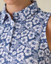 Moloka'i Sleeveless Polo in Moonlight, close-up detail view on model featuring a slate blue base with a white hibiscus and tropical leaf print and spread collar