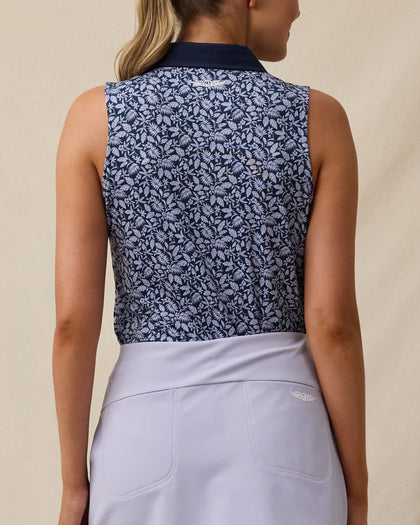Back view of the Women's Huli Sleeveless Polo in New Indigo showcasing the allover tropical leaf and floral print