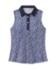 Women's Huli Sleeveless Polo in New Indigo featuring an allover tropical leaf and floral print in soft lavender tones on a deep indigo background, with a solid indigo collar