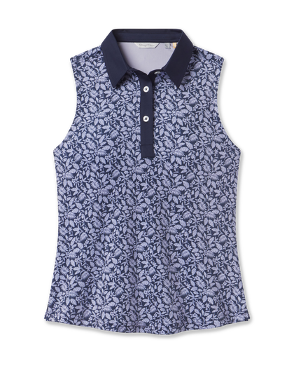 Women's Huli Sleeveless Polo in New Indigo featuring an allover tropical leaf and floral print in soft lavender tones on a deep indigo background, with a solid indigo collar