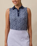 Model wearing the Women's Huli Sleeveless Polo in New Indigo with a tropical leaf and floral print and solid indigo collar