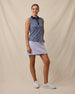 Model wearing the Women's Huli Sleeveless Polo in New Indigo untucked with a light lavender golf skort