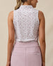 Back view of the Women's Erika Sleeveless Polo in White showcasing the intricate floral vine print across the sleeveless design