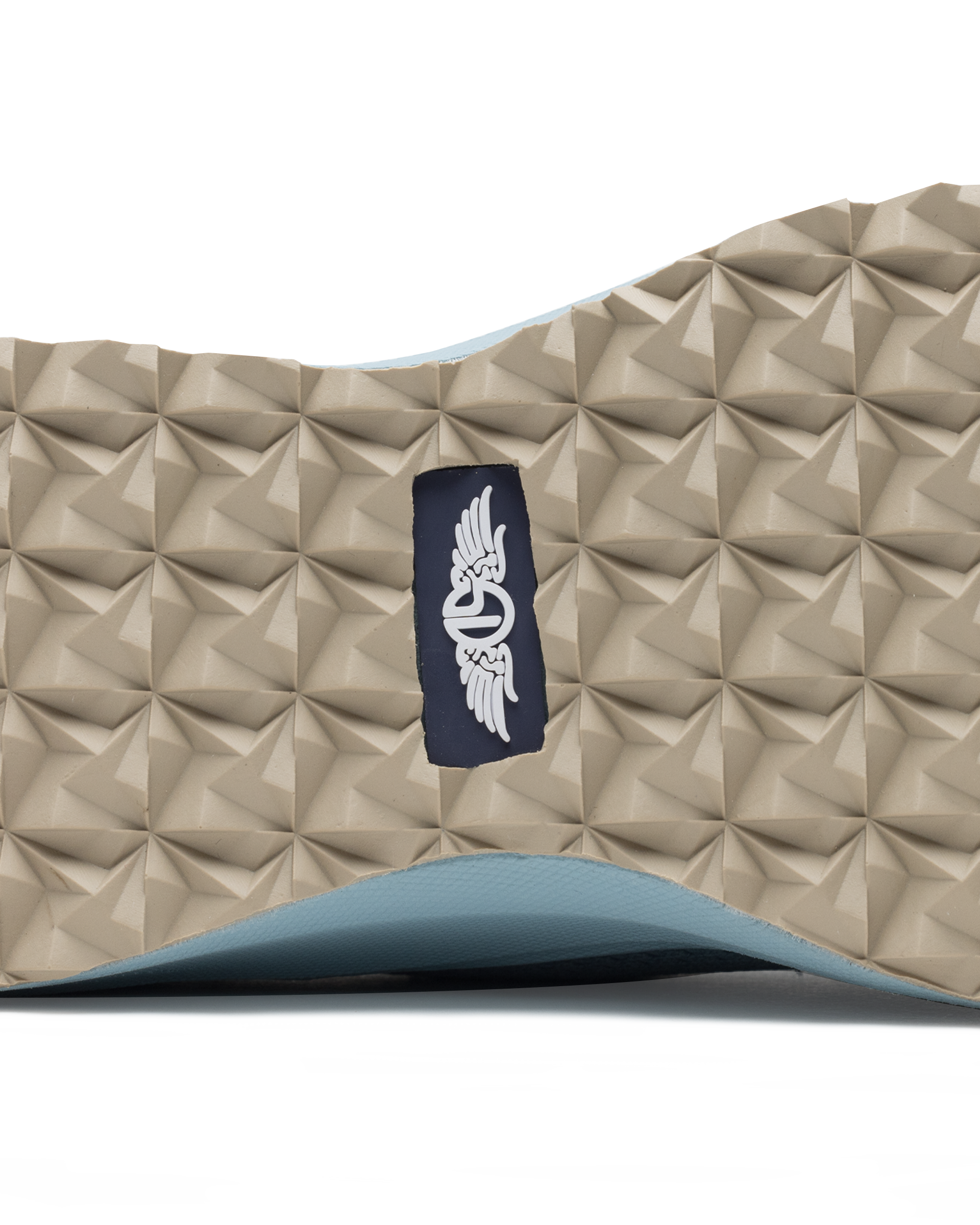 Swing Shoe in Mineral, close-up bottom view featuring the tan geometric traction outsole with Straight Down navy logo label at the center and light blue midsole edge