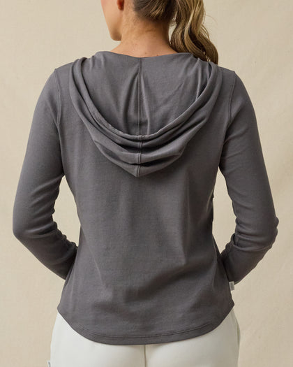 Back view of a woman wearing the Thyme Hoodie in Nightshade, highlighting the relaxed hood and long-sleeve silhouette.