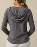 Back view of a woman wearing the Thyme Hoodie in Nightshade, highlighting the relaxed hood and long-sleeve silhouette.