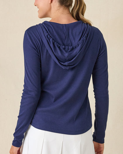 Thyme Quarter Zip Hoodie in New Indigo, back view on model in solid navy ribbed texture with drawstring hood, paired with a white pleated skort