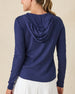 Thyme Quarter Zip Hoodie in New Indigo, back view on model in solid navy ribbed texture with drawstring hood, paired with a white pleated skort