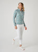 Women's Ava Quarter Zip in Sea Green, full-length front model view featuring a teal long-sleeve pullover with an all-over pink floral vine print styled with white pants and white shoes