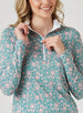 Women's Ava Quarter Zip in Sea Green, detail model view highlighting the quarter-zip closure, contrast white zipper pull, and white interior collar lining against the teal and pink floral vine print fabric
