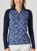 Mabel Quarter Zip in New Indigo, front model view featuring a long-sleeve pullover with an allover navy and blue abstract floral print body, solid navy raglan sleeves, quarter zip, and navy mock neck collar, paired with white pants