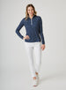 Women's Galaxy Quarter Zip in New Indigo, full-length front model view featuring a navy long-sleeve pullover with an all-over scattered white and teal polka dot print styled with white pants and white shoes