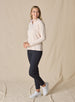 Women's Ellen Quarter Zip in Peche, side view on model featuring a soft peach textured performance fabric with a quarter-zip stand collar, raglan sleeves, and white zipper detail, paired with black pants and white shoes