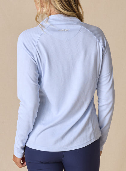 Women's Ellen Quarter Zip in Powder, back view on model featuring a soft powder blue textured performance fabric with raglan sleeve construction and tonal Straight Down logo at the upper back, paired with navy pants