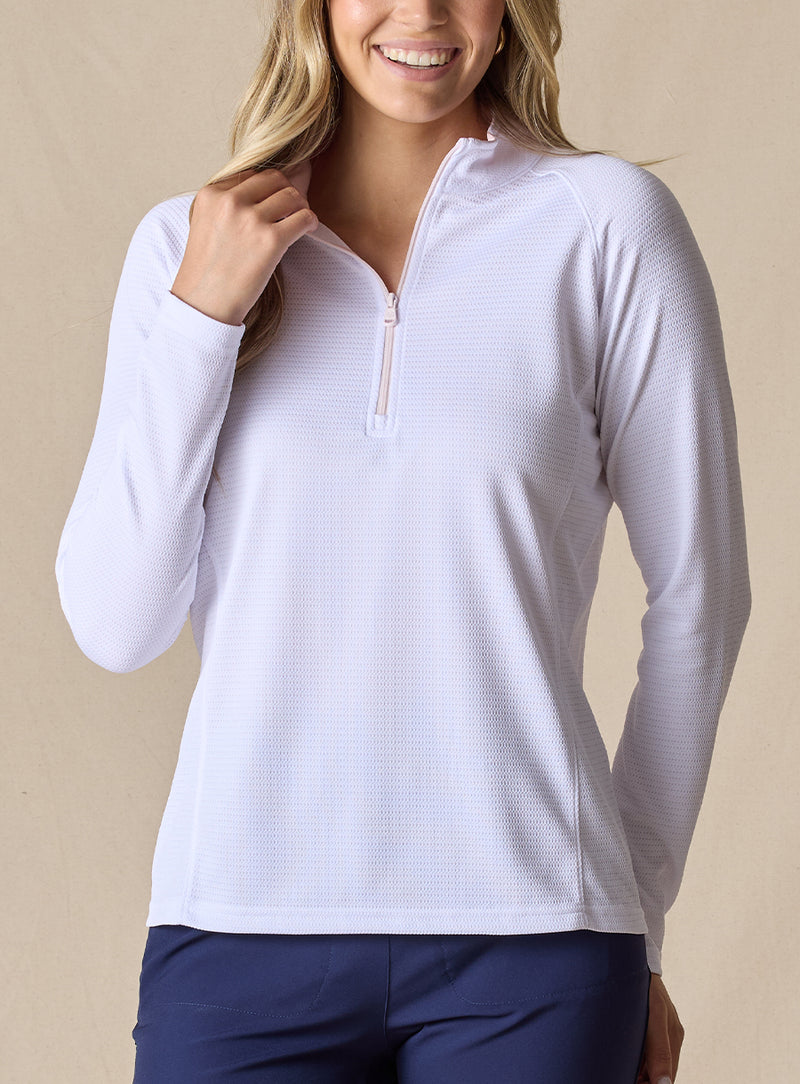 Women's Ellen Quarter Zip in White, front view on model featuring a white textured performance fabric with a quarter-zip collar, raglan sleeves, and blush pink zipper detail, paired with navy pants