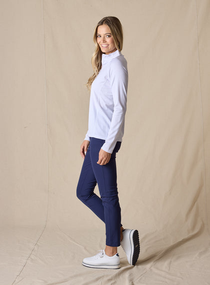 Women's Ellen Quarter Zip in White, side view on model featuring a white textured performance fabric with a quarter-zip stand collar and raglan sleeves, paired with navy pants and white shoes