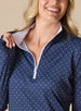 Dottie Quarter Zip in Cedar, close-up front model view highlighting the quarter zip closure, white mock neck collar with white interior lining, and allover pink polka dot print on navy fabric