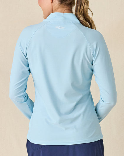 Clara Quarter Zip in Gemstone, back view featuring a solid light blue long sleeve pullover with Straight Down embroidered logo at the upper back, paired with navy pants