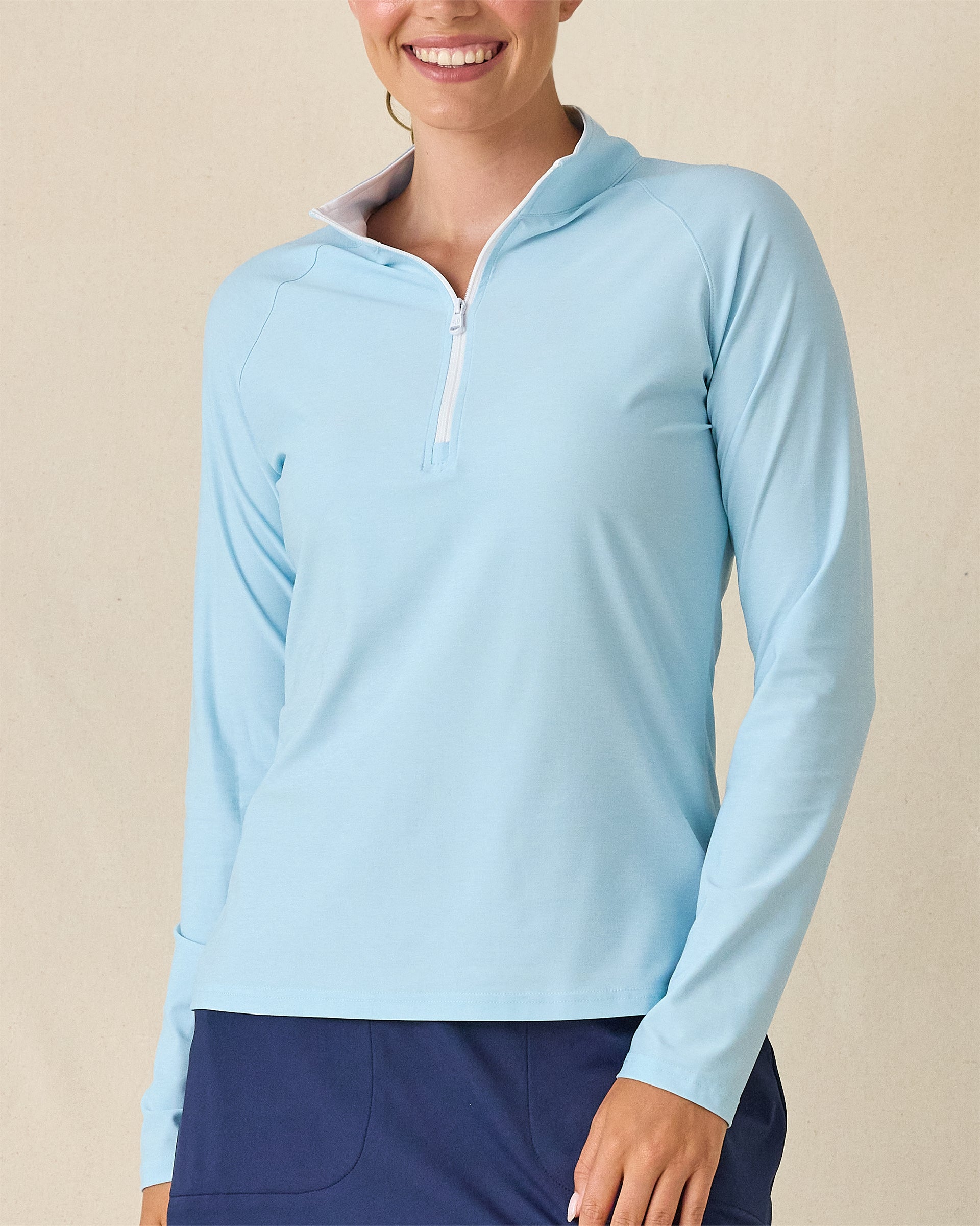 Clara Quarter Zip in Gemstone, front view featuring a solid light blue long sleeve pullover with white quarter zip and white contrast collar lining, paired with navy pants