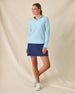 Clara Quarter Zip in Gemstone, full length front view featuring a solid light blue long sleeve pullover with white quarter zip and white contrast collar lining, paired with a navy skort and white golf shoes