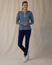 Women's Flores Quarter Zip in New Indigo, full-length front on-model view featuring a navy long sleeve quarter zip pullover with an allover small floral print in white and mint green tones, mock neck collar, and white zipper, paired with navy pants and white shoes