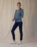 Women's Flores Quarter Zip in New Indigo, full-length front on-model view with a relaxed stance featuring a navy long sleeve quarter zip pullover with an allover small floral print in white and mint green tones, mock neck collar, and white zipper, paired with navy pants and white shoes