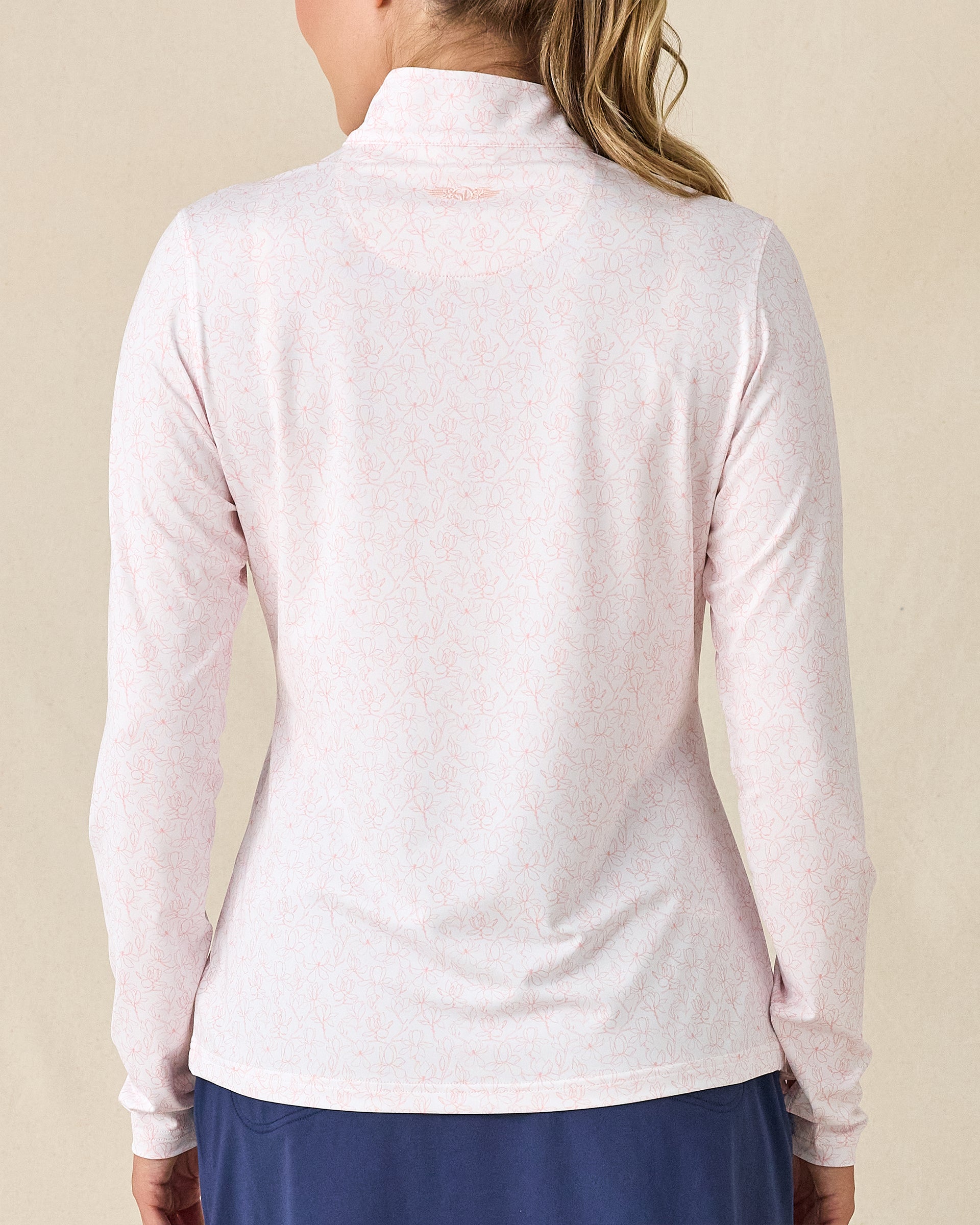 Royal Orchid Quarter Zip in Pearl, back view featuring a white base with pink floral line-drawn allover print pattern with Straight Down embroidered logo at the upper back, paired with navy pants