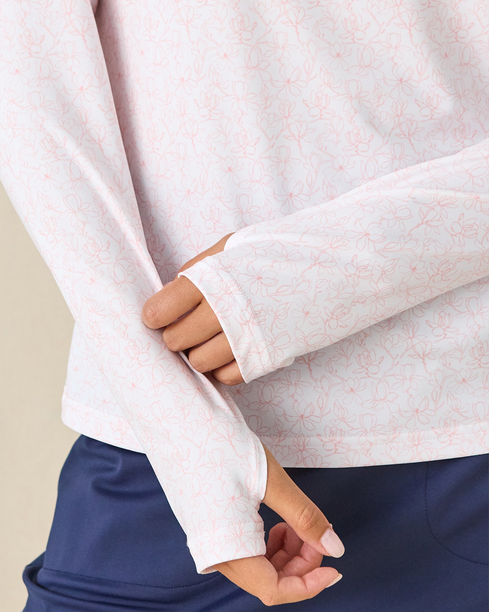 Royal Orchid Quarter Zip in Pearl, close-up detail view featuring the thumb hole cuff and pink floral line-drawn print on a white base