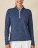 Cherry Bloom Quarter Zip in New Indigo, front close-up view on model featuring a navy base with a scattered white and pink floral print and white quarter zip and white collar interior, paired with white pants