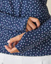 Cherry Bloom Quarter Zip in New Indigo, close-up detail view on model featuring a thumbhole cuff with a scattered white and pink floral print