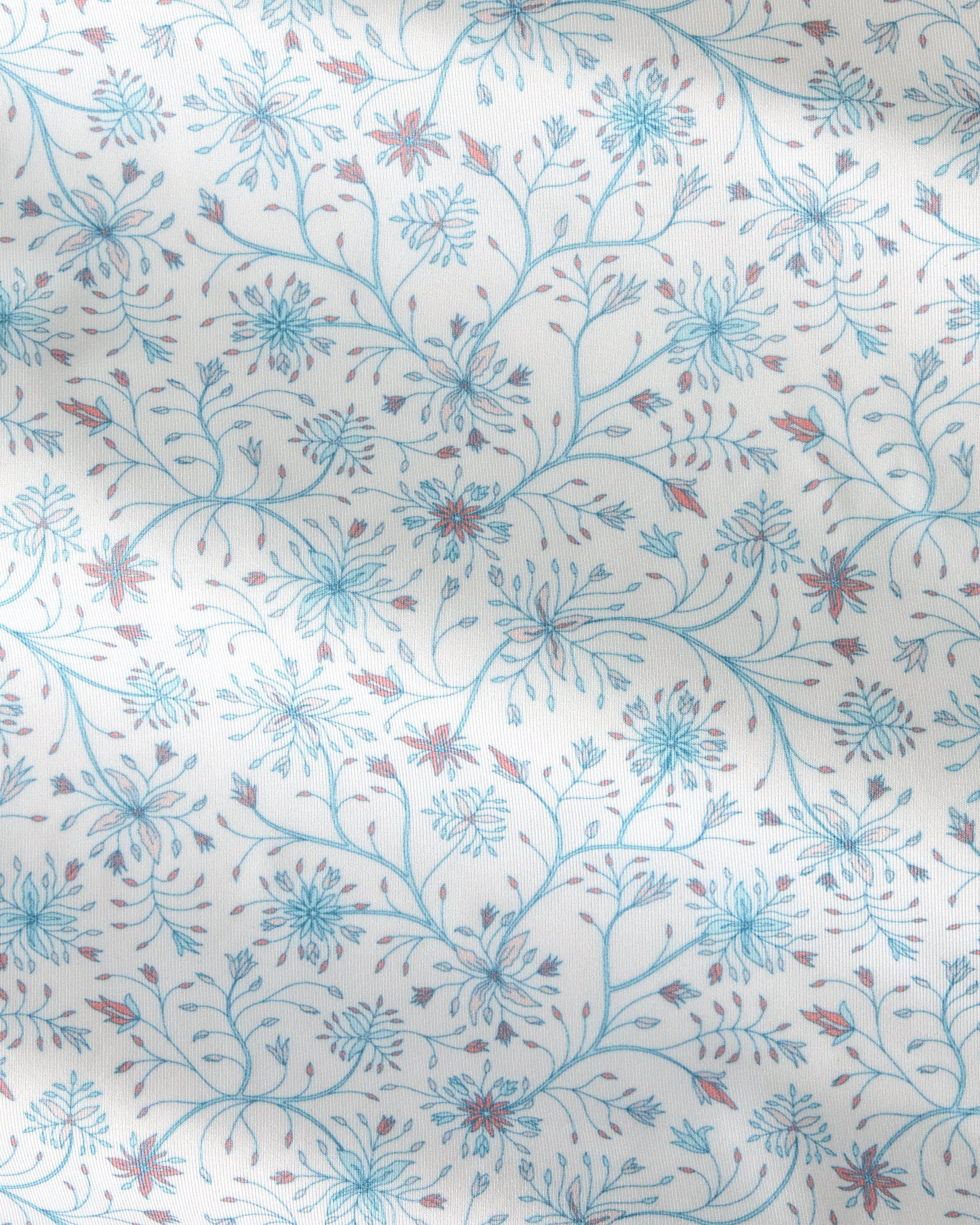A close-up of a fabric or wallpaper pattern featuring delicate blue and reddish-brown floral vines on a warm off-white background.