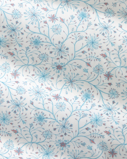 A close-up of a fabric or wallpaper pattern featuring delicate blue and reddish-brown floral vines on a warm off-white background.
