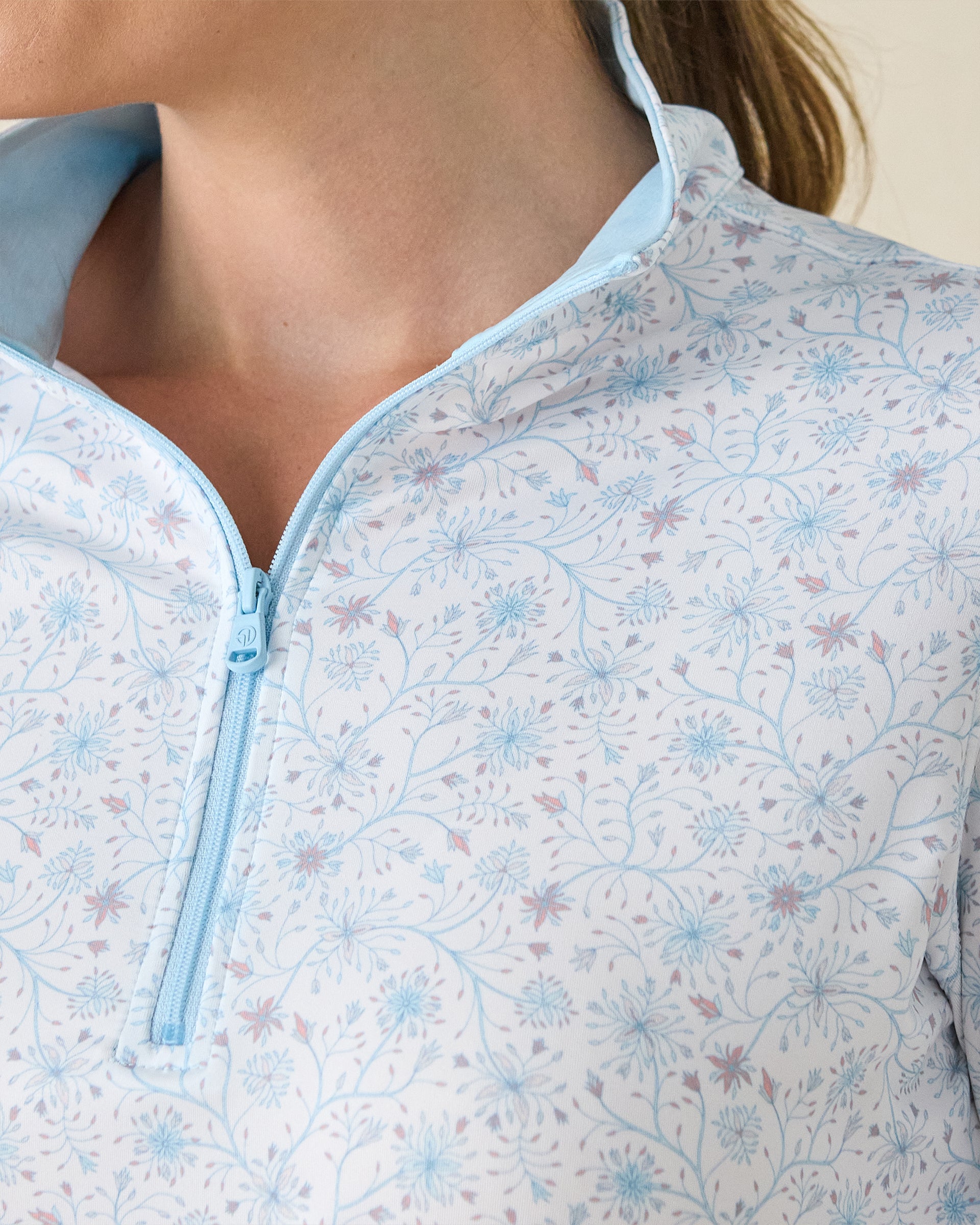 Mariette Quarter Zip in Gemstone, close-up detail view featuring the light blue quarter zip and light blue contrast collar lining with light blue and mauve floral vine print on a white base