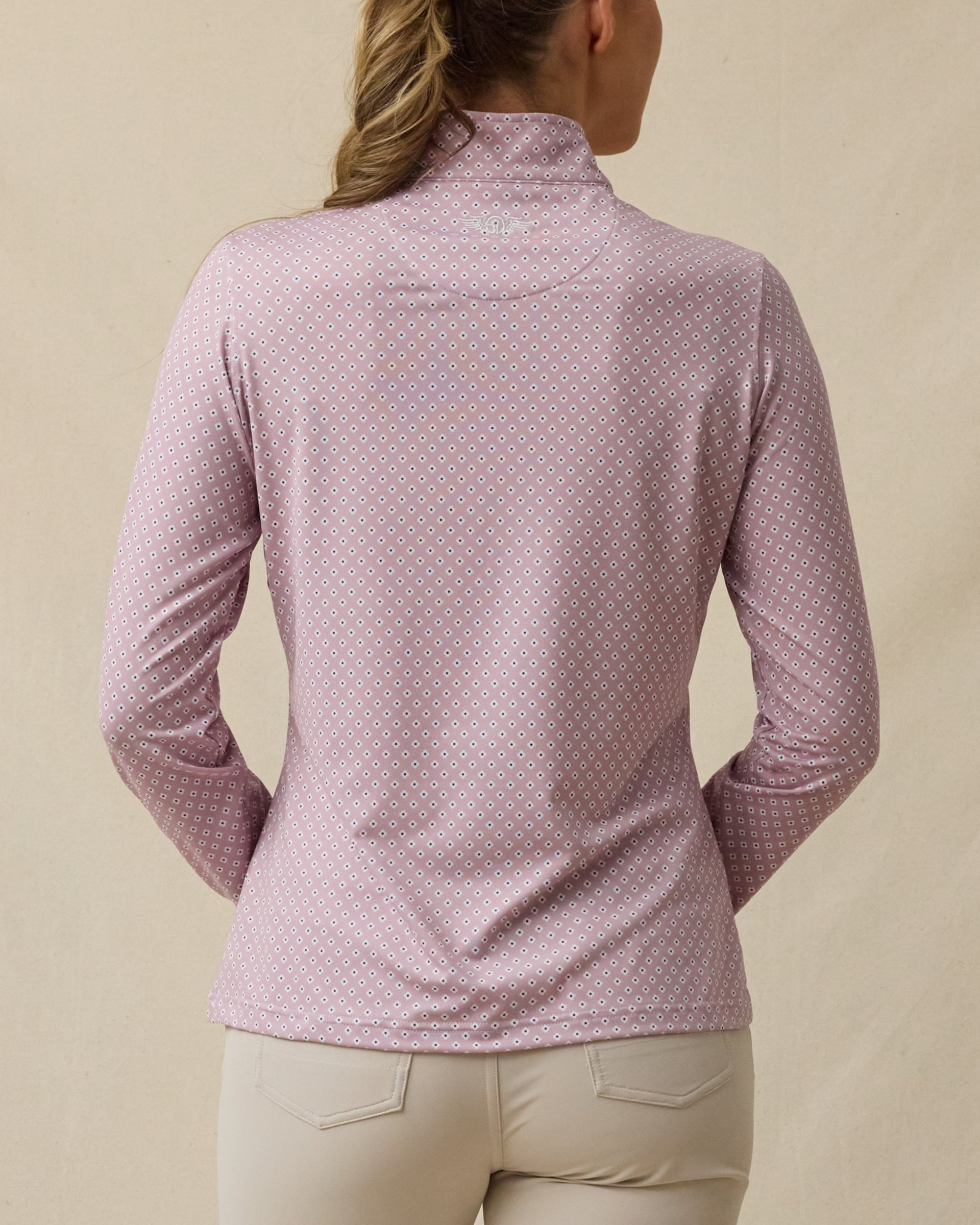 Back view of the Empress Quarter Zip in Pink Dawn featuring an allover geometric floral print and logo just below the collar