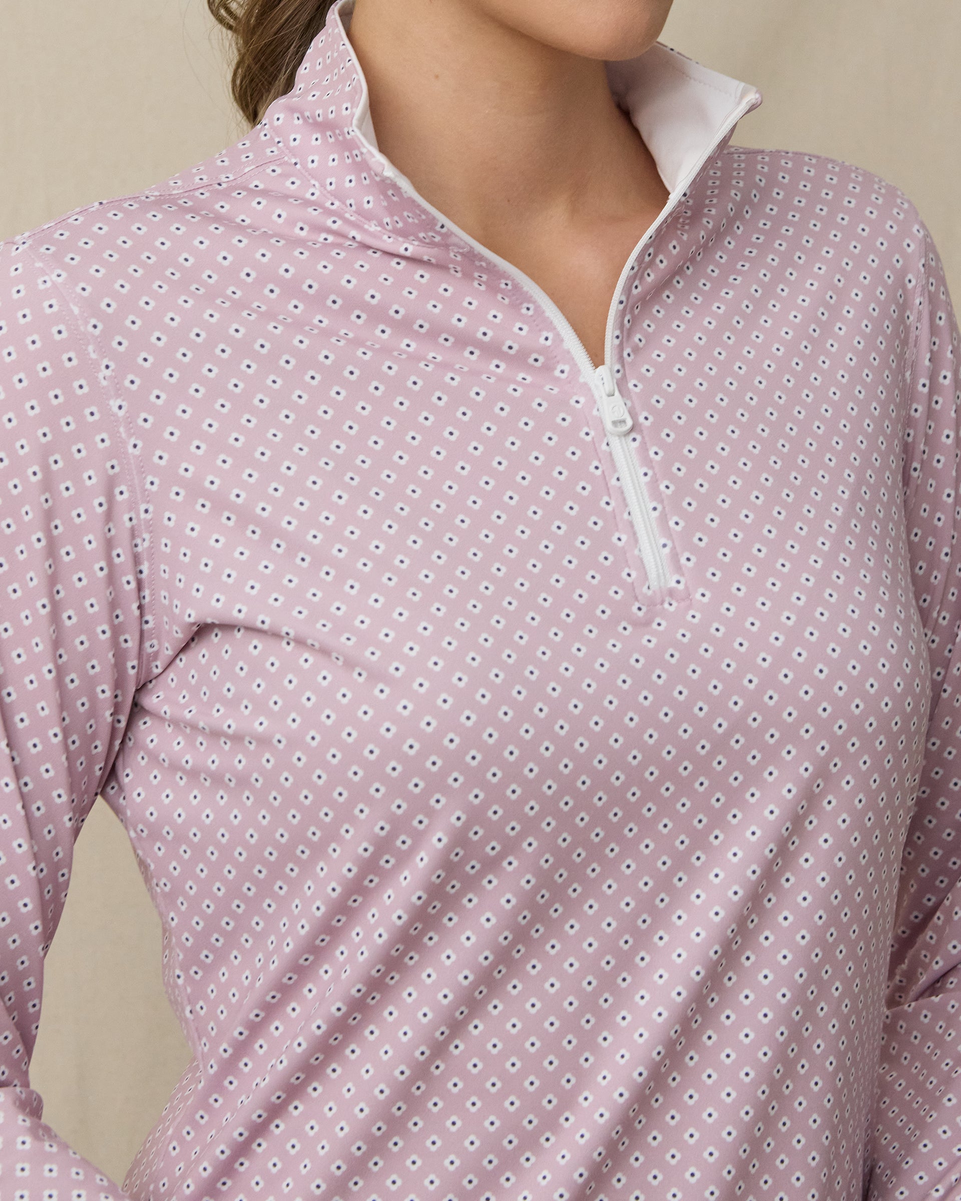Close-up of the Empress Quarter Zip in Pink Dawn showcasing the geometric floral print