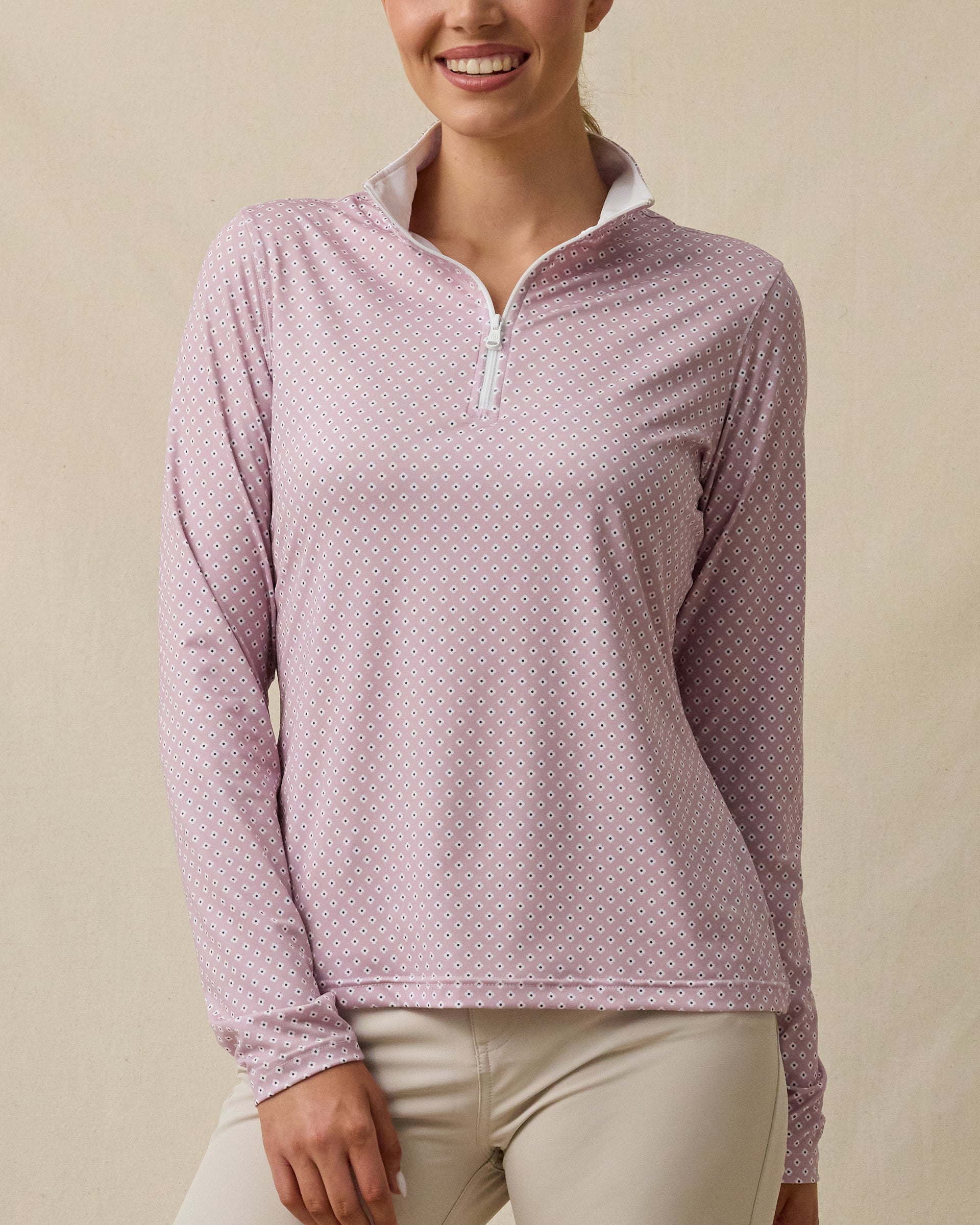 Model wearing the Empress Quarter Zip in Pink Dawn featuring a geometric floral print, front view