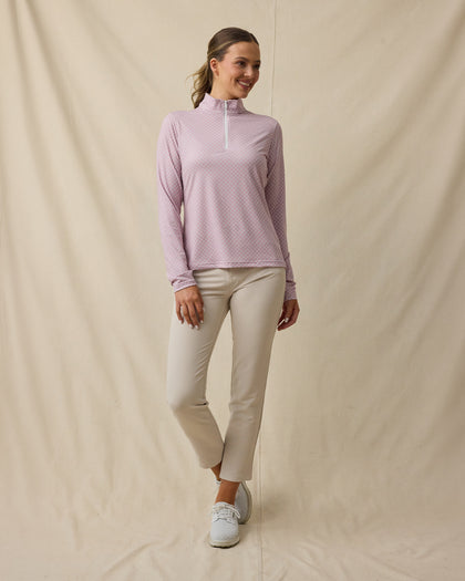 Model wearing the Empress Quarter Zip in Pink Dawn paired with beige golf pants