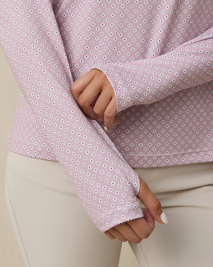 Close-up of the Empress Quarter Zip in Pink Dawn showing the geometric floral print and thumbhole cuff detail