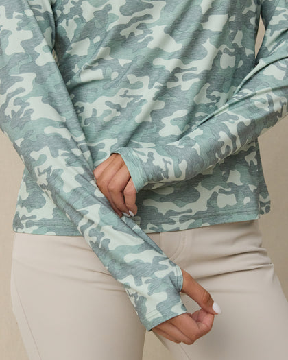Close-up of the lighter and darker green camouflage top showing the long sleeves and extended cuffs with thumbholes.