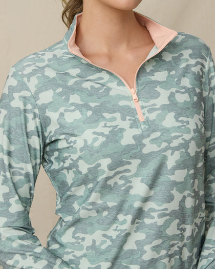 Close-up of the green camouflage quarter-zip top showing the light peach zipper and contrasting light peach interior collar.
