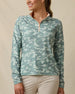 Front close-up of a woman wearing a long-sleeve quarter-zip top with a lighter and darker green camouflage print, light peach zipper, and light peach contrast collar.