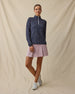Model wearing the Erika Quarter Zip in New Indigo zipped to the collar with a coordinating pink dawn golf skort